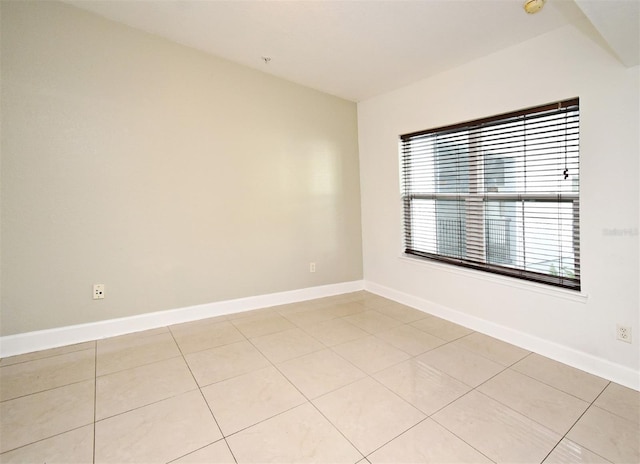 unfurnished room featuring baseboards and light tile patterned flooring