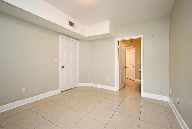 unfurnished room with light tile patterned floors, visible vents, and baseboards