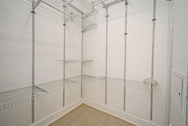 walk in closet with light tile patterned floors