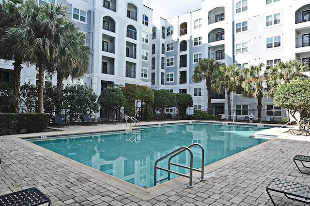 community pool with fence and a patio