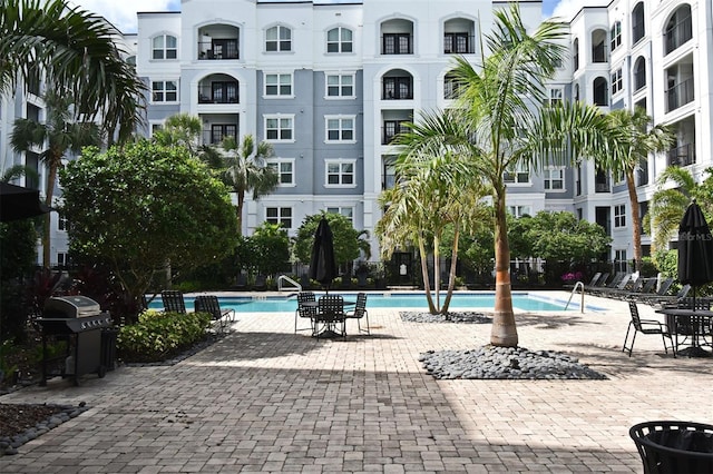 pool with a patio area and a grill