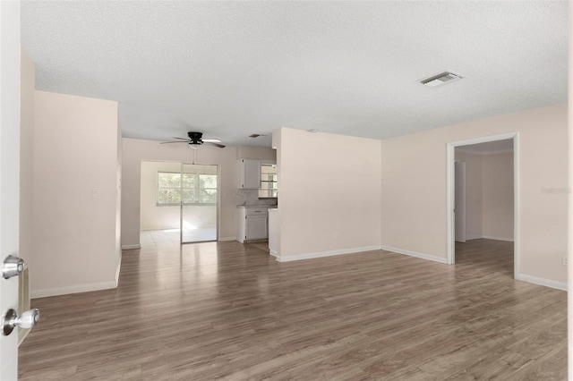 unfurnished room with ceiling fan, light wood-style flooring, visible vents, and baseboards