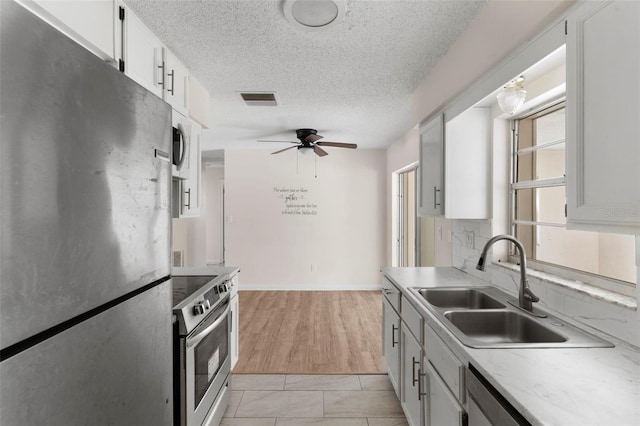 kitchen with tasteful backsplash, light countertops, visible vents, appliances with stainless steel finishes, and a ceiling fan