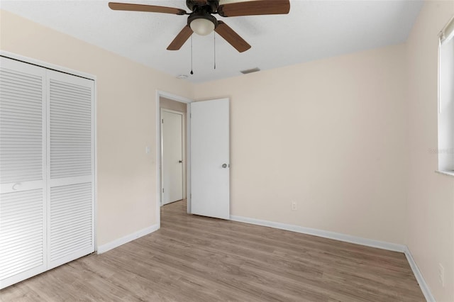 unfurnished bedroom with visible vents, baseboards, a ceiling fan, light wood-type flooring, and a closet