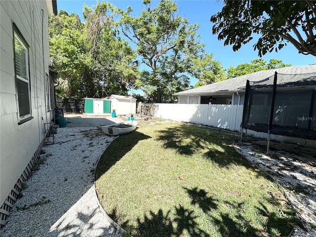 3025 W N A St, Tampa, FL 33609 - view of yard featuring a storage shed, an outdoor structure, a trampoline, and a fenced backyard