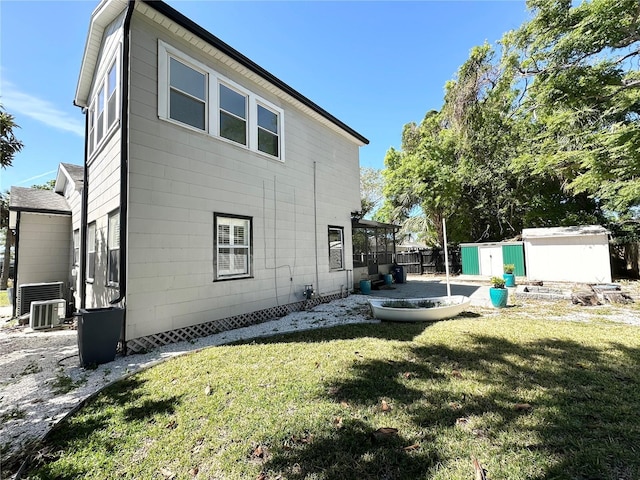 3025 W N A St, Tampa, FL 33609 - rear view of property featuring a shed, central air condition unit, a lawn, an outdoor structure, and a patio