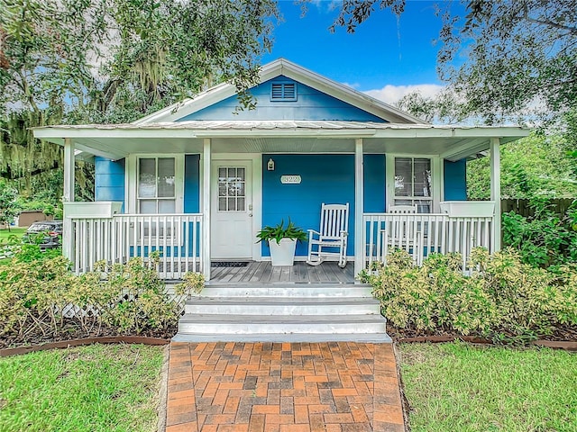 bungalow-style house featuring metal roof and a porch