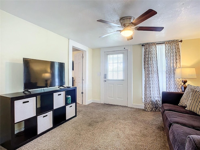 carpeted living area featuring ceiling fan, a textured ceiling, and baseboards