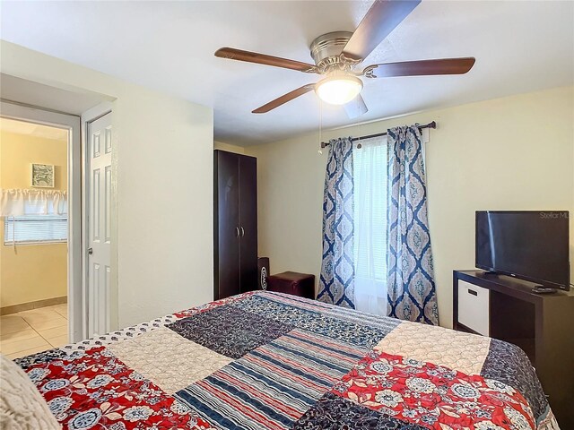 bedroom with light tile patterned floors, baseboards, and a ceiling fan