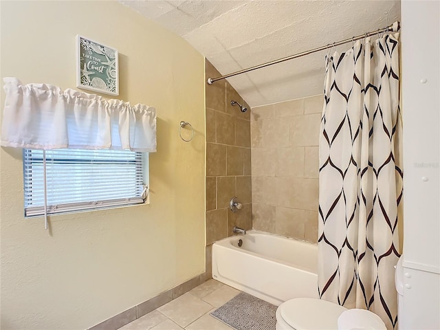 bathroom with toilet, shower / bath combo with shower curtain, a textured ceiling, tile patterned flooring, and baseboards