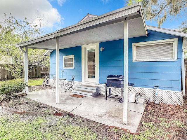 rear view of house featuring entry steps, a patio, and fence