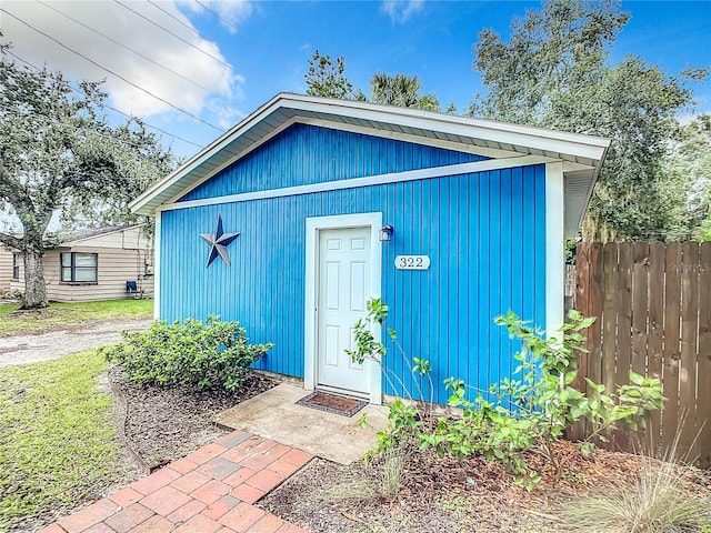 view of outbuilding with fence and an outdoor structure