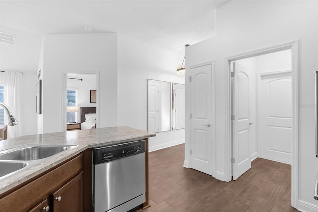 kitchen with visible vents, dark wood-style flooring, light countertops, stainless steel dishwasher, and a sink