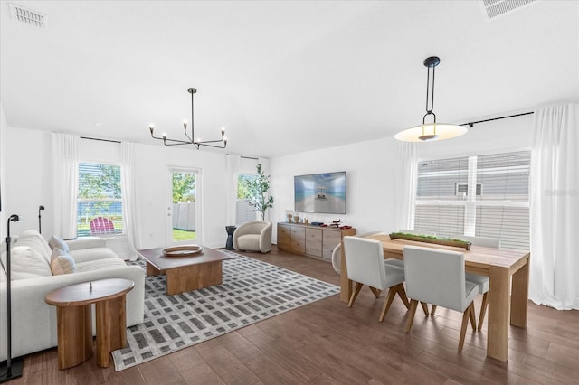 living room featuring visible vents, a chandelier, and wood finished floors