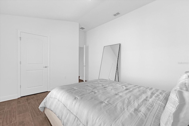 bedroom featuring lofted ceiling, visible vents, and wood finished floors