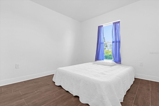 bedroom with baseboards and wood tiled floor