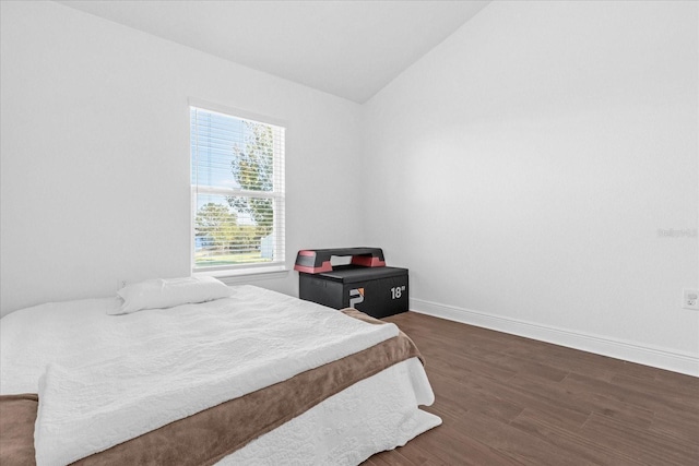 bedroom featuring vaulted ceiling, wood finished floors, and baseboards