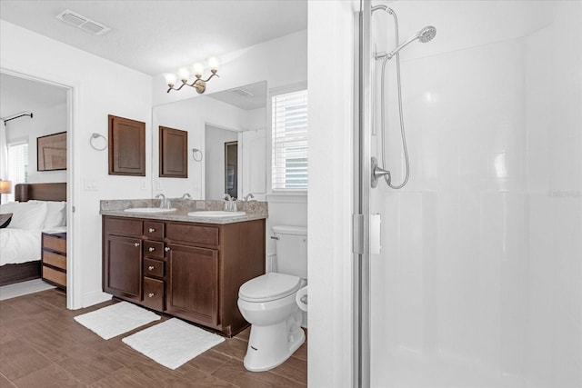 ensuite bathroom featuring a stall shower, visible vents, a sink, and ensuite bathroom