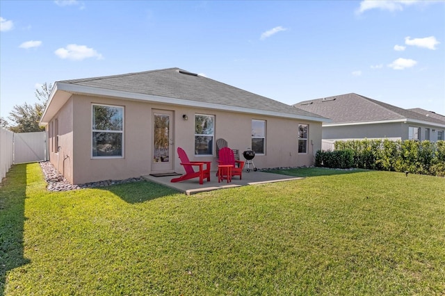 back of property with roof with shingles, a patio, stucco siding, a lawn, and a fenced backyard