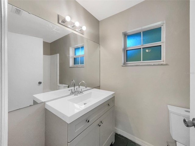 bathroom featuring baseboards, visible vents, vanity, and toilet