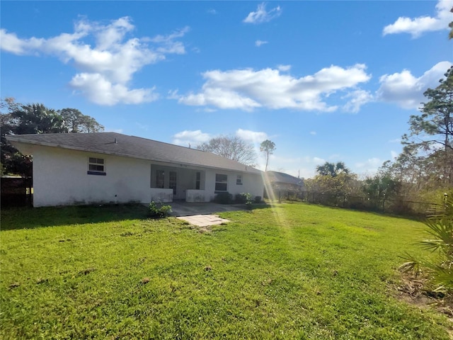 back of property with a lawn, a fenced backyard, and stucco siding