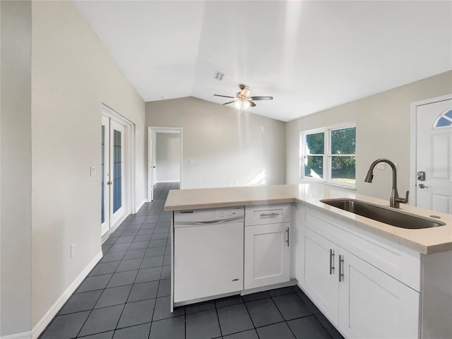 kitchen with visible vents, dishwasher, lofted ceiling, white cabinetry, and a sink