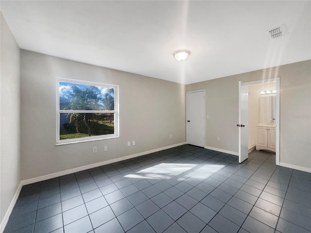 unfurnished bedroom with tile patterned flooring, visible vents, and baseboards