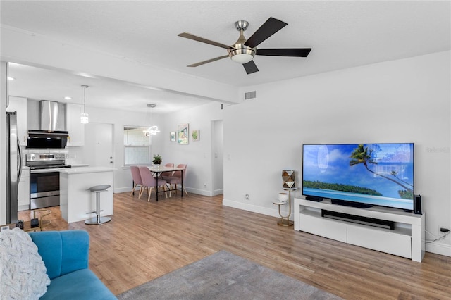 living area featuring baseboards, beam ceiling, and light wood-style floors