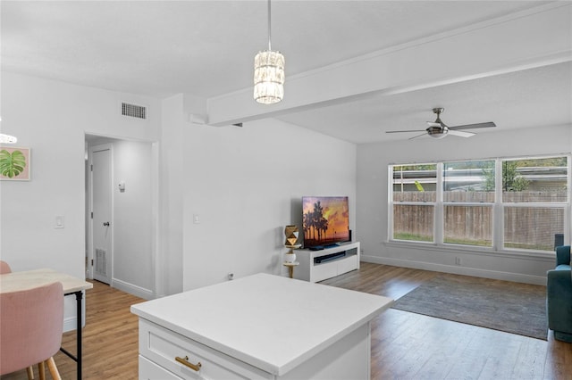 living room featuring visible vents, beamed ceiling, baseboards, and wood finished floors