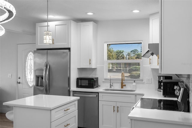 kitchen featuring stainless steel appliances, a sink, white cabinetry, light countertops, and backsplash