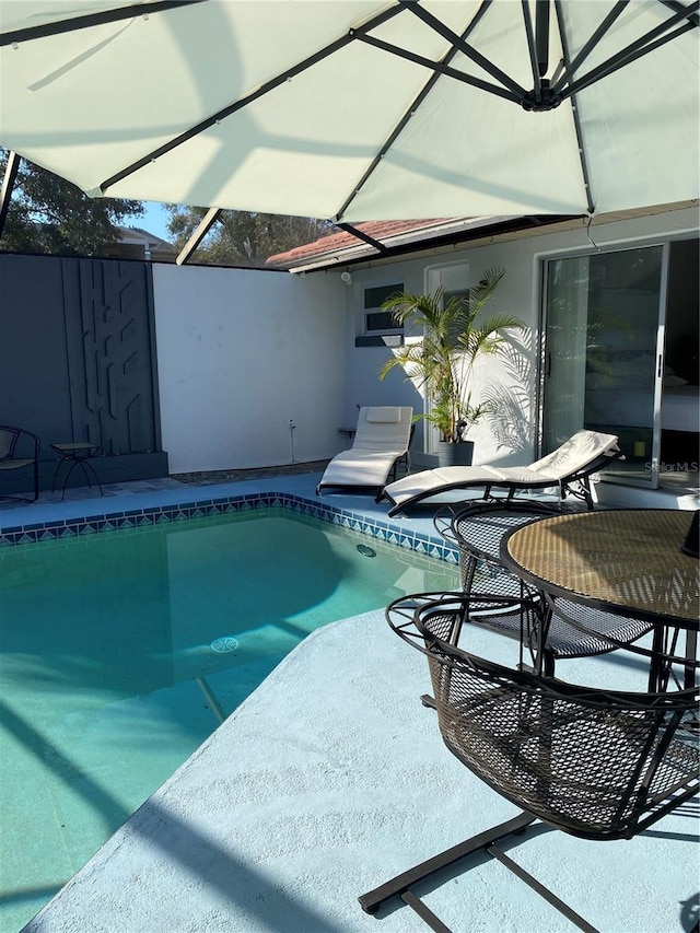 view of swimming pool featuring a fenced in pool, a lanai, and a patio area