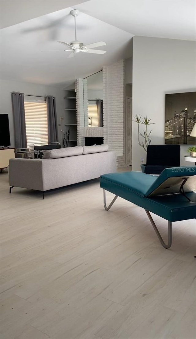 living room with lofted ceiling, a ceiling fan, and wood finished floors