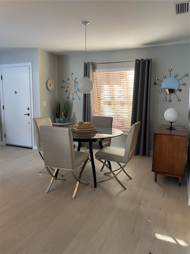 dining space with light wood-type flooring and visible vents