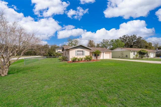 ranch-style home featuring a front lawn, concrete driveway, fence, and an attached garage