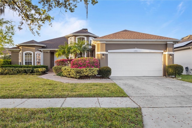 view of front of house featuring a garage, a front yard, and stucco siding