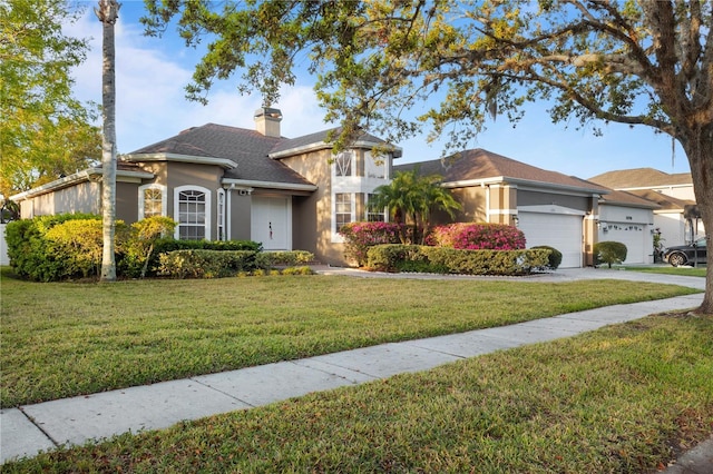 view of front of property with an attached garage, driveway, stucco siding, a front lawn, and a chimney