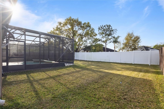 view of yard with a fenced backyard, a fenced in pool, and a lanai