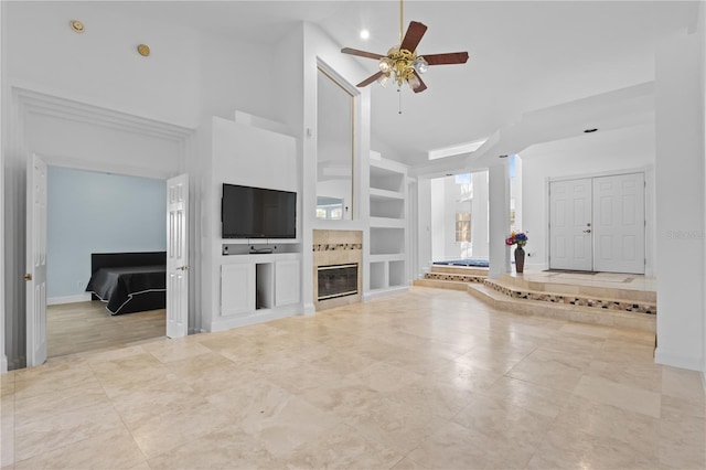 unfurnished living room featuring baseboards, ceiling fan, built in shelves, high vaulted ceiling, and a fireplace