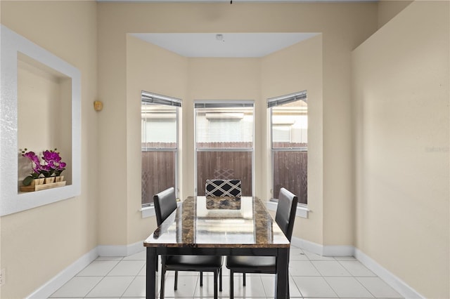 dining space featuring baseboards and light tile patterned flooring