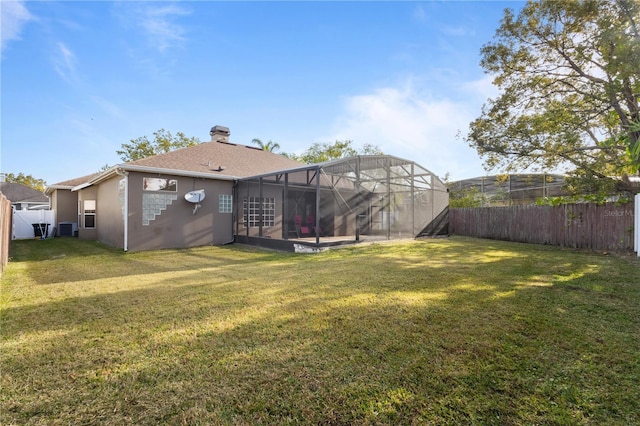 view of yard with glass enclosure, a fenced backyard, and central AC