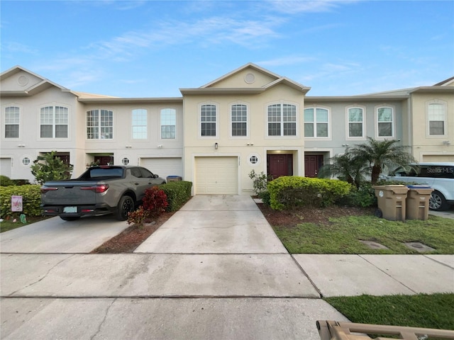 view of property featuring driveway, an attached garage, and stucco siding