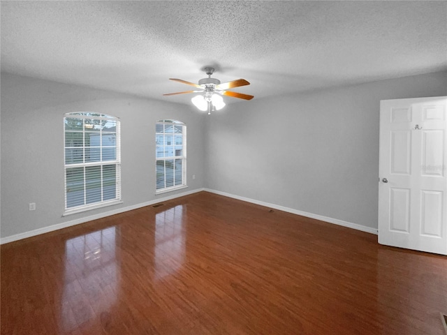 unfurnished room featuring ceiling fan, a textured ceiling, baseboards, and wood finished floors