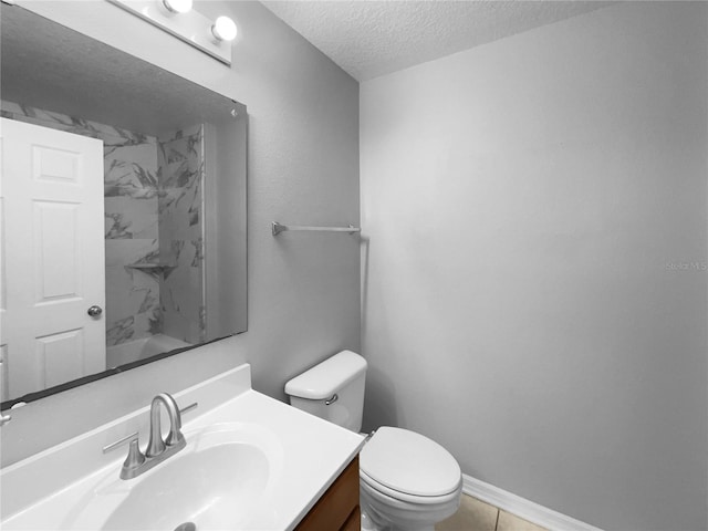 bathroom with a textured ceiling, toilet, vanity, baseboards, and walk in shower