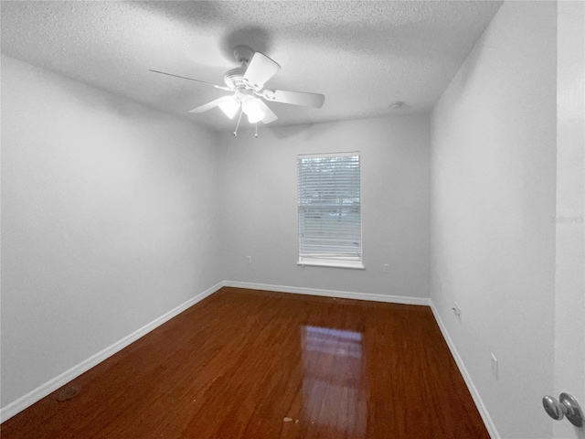 unfurnished room with a ceiling fan, a textured ceiling, baseboards, and wood finished floors