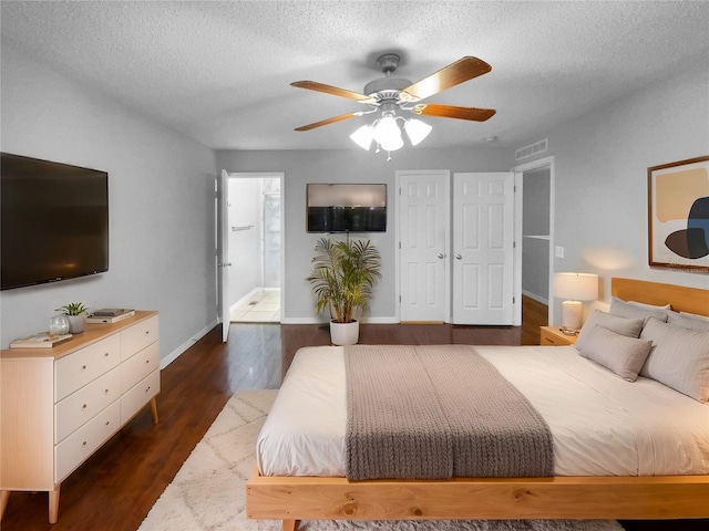 bedroom with dark wood-style flooring, visible vents, a textured ceiling, and baseboards