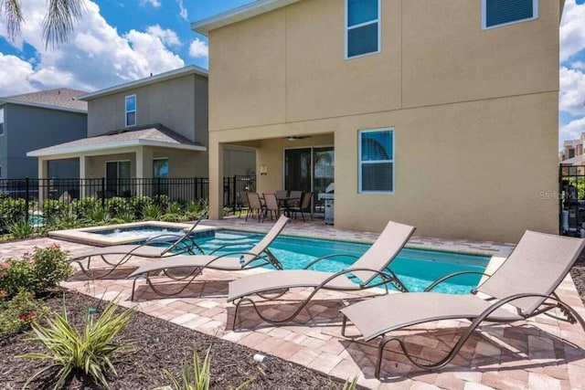 view of pool featuring a patio area, a swimming pool, an in ground hot tub, and fence