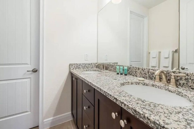 7568 Marker Ave, Kissimmee, FL 34747 - bathroom featuring double vanity, baseboards, and a sink