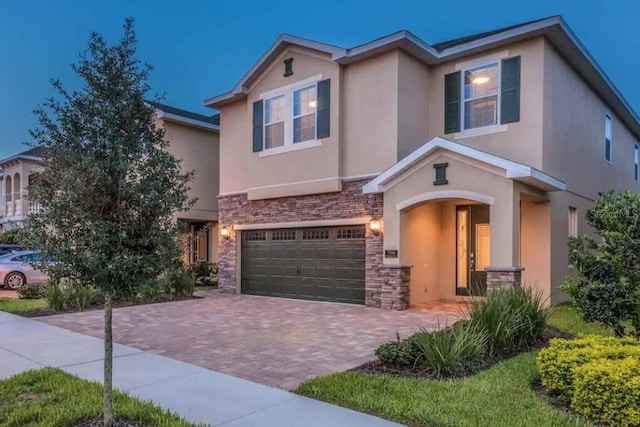 7568 Marker Ave, Kissimmee, FL 34747 - view of front of property with stone siding, stucco siding, an attached garage, and decorative driveway