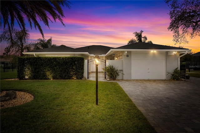 single story home featuring a gate, fence, and decorative driveway