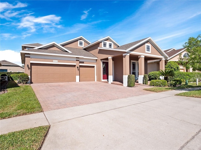 view of front of home with stucco siding, decorative driveway, and a garage